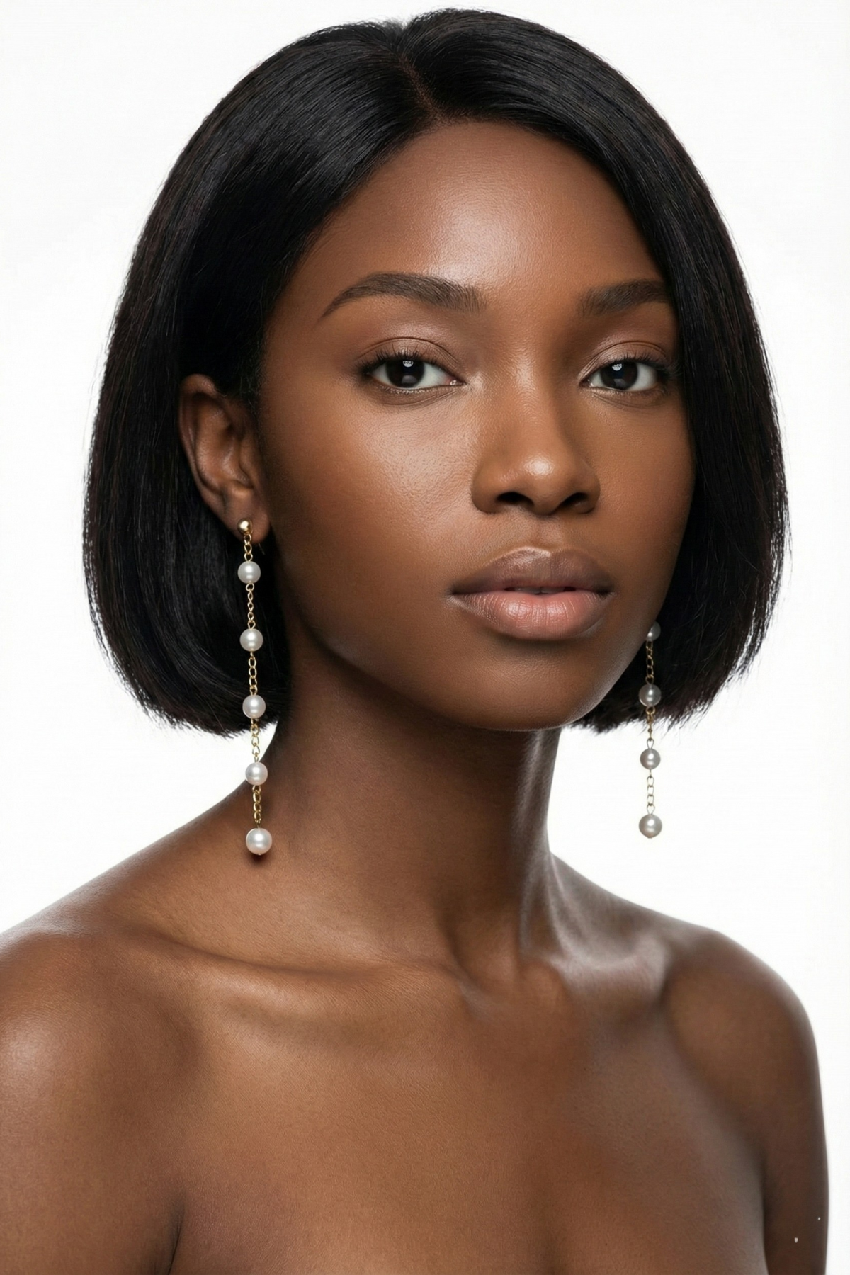 Boucles d’oreilles Luxembourg dorées, longues de 10 cm, composées d’une chaîne fine ornée de pierres scintillantes, portées par une femme brune au carré sur fond blanc. Bijou de mariage élégant et aérien.