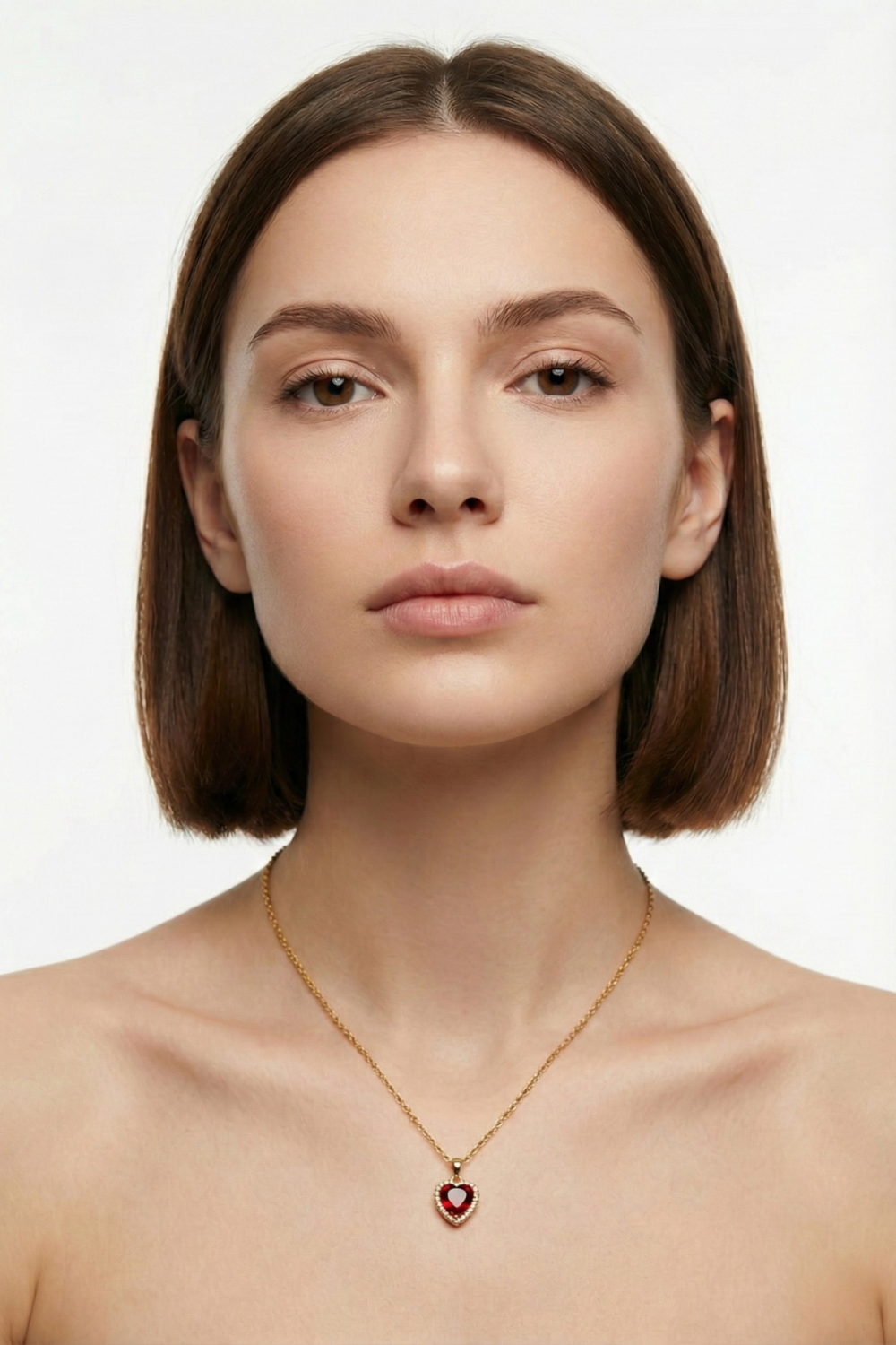 Collier Paris mon Amour doré avec pendentif cœur rouge en zircone cubique, porté par une femme brune au carré sur fond blanc. Bijou romantique et élégant.