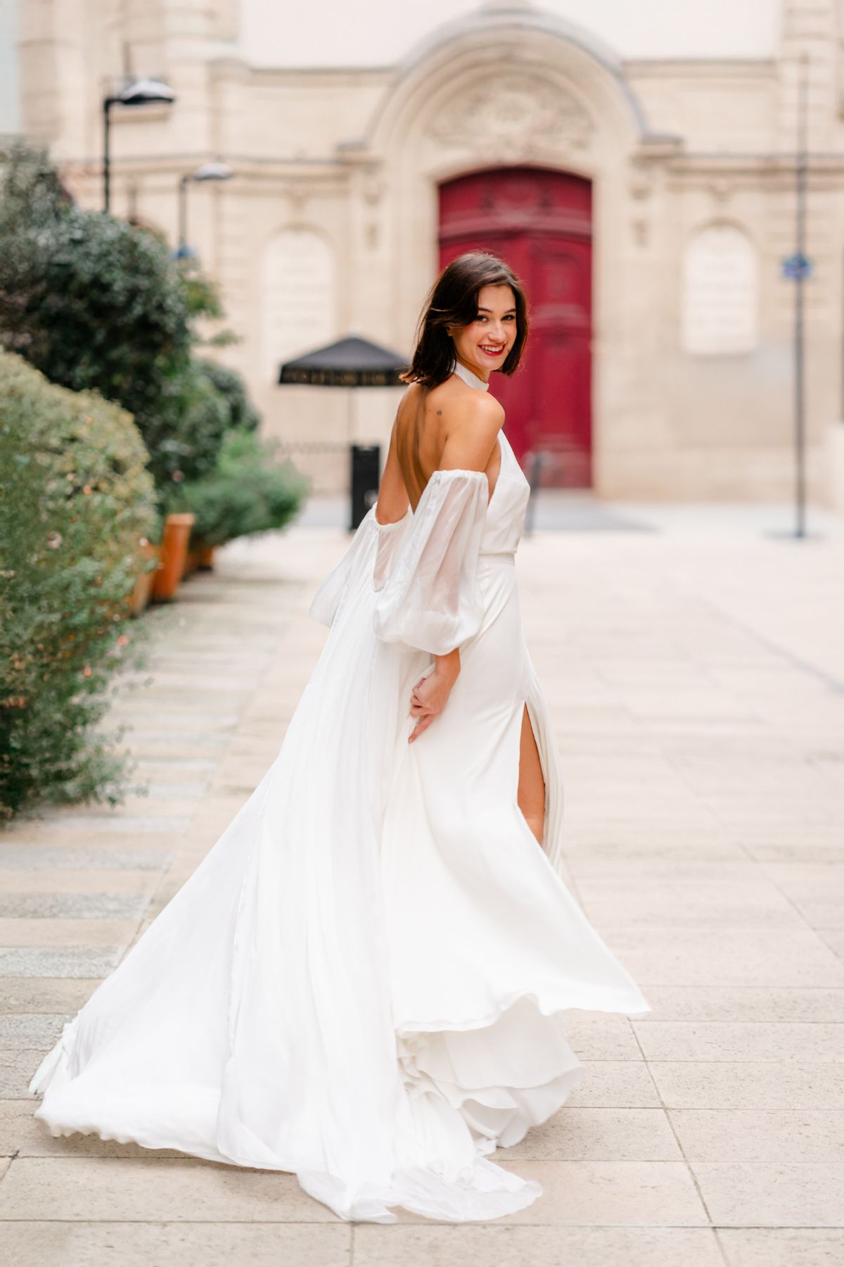 Robe de mariée Olympe en crêpe de soie blanc, dos nu et encolure américaine, silhouette fluide et jupe fendue – The Wedding Room Paris